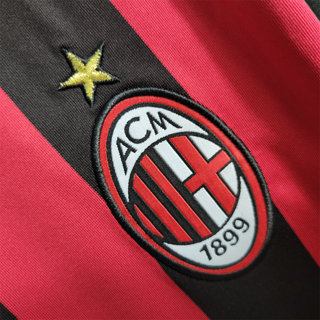 Dettaglio_maglia_Milan_2009_10_stemma_club_su_sfondo_rossonero.jpg