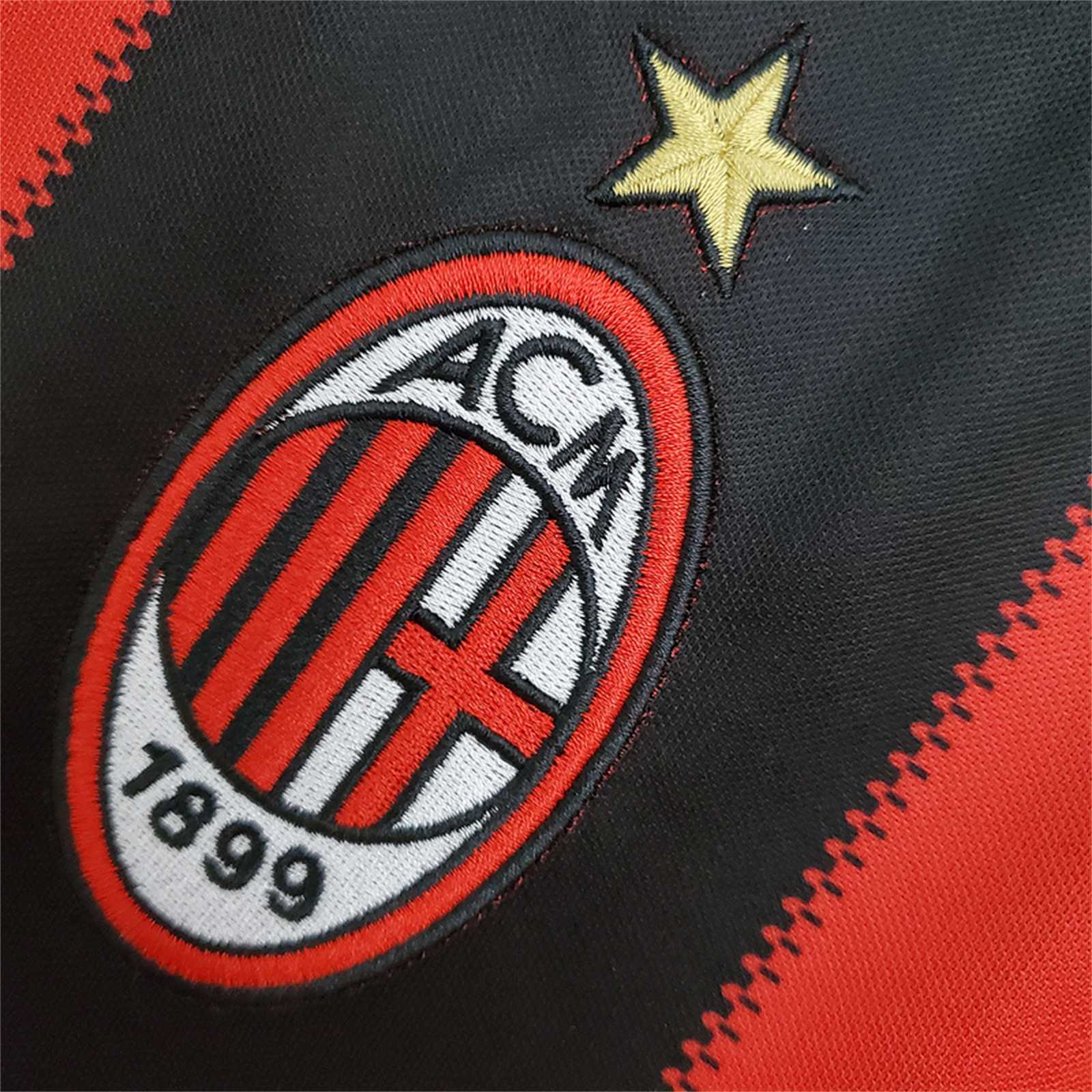 Dettaglio_maglia_Milan_2010_11_stemma_club_su_sfondo_rossonero.jpg