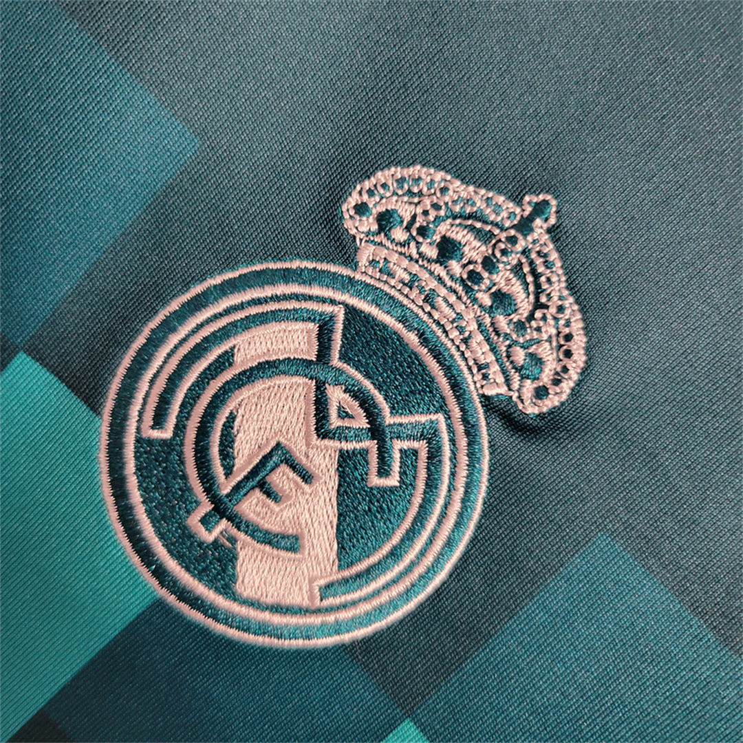 Dettaglio_ravvicinato_dello_stemma_del_club_Real_Madrid_ricamato_in_bianco_su_tessuto_turchese.png