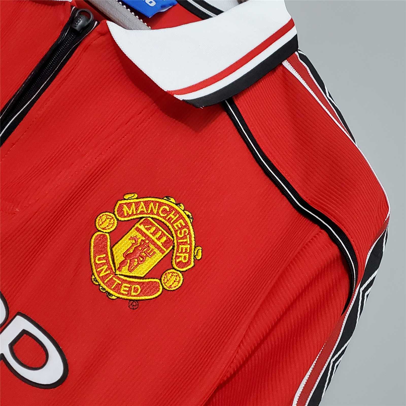 Dettaglio_stemma_Manchester_United_su_maglia_home_1998_99.jpg