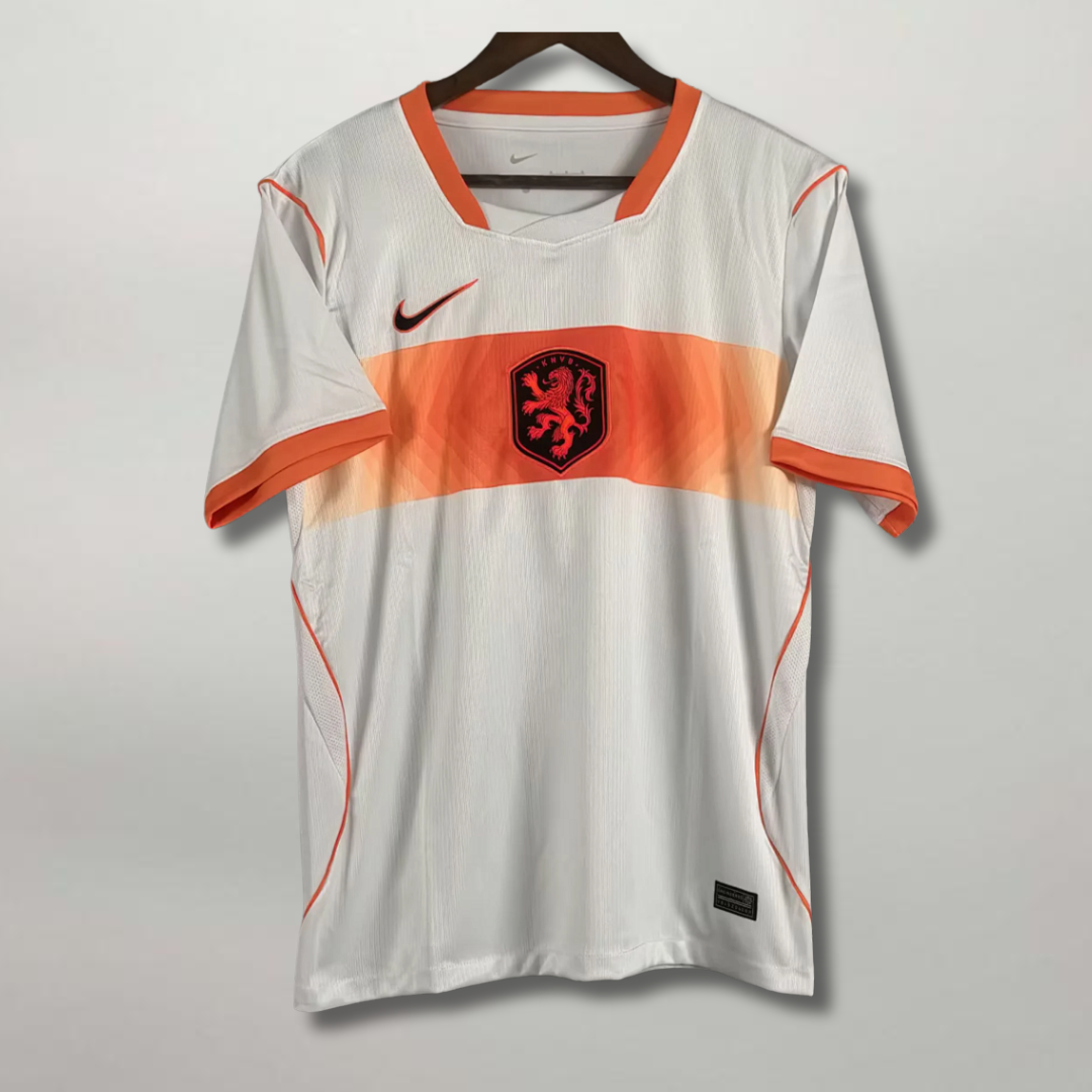 Fronte_della_maglia_away_dell_Olanda_2026_chiara_con_fascia_orizzontale_arancione_sul_petto_e_stemma_del_leone.png