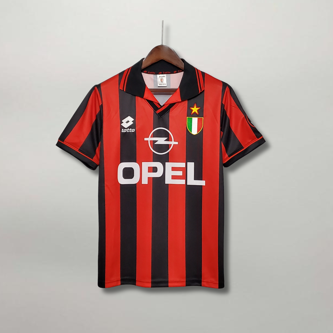 Fronte_maglia_Milan_1995_96_con_strisce_rosse_e_nere_colletto_a_polo_e_Scudetto._8ba3de06-a127-41f3-a7eb-1d0d008df1d4.png
