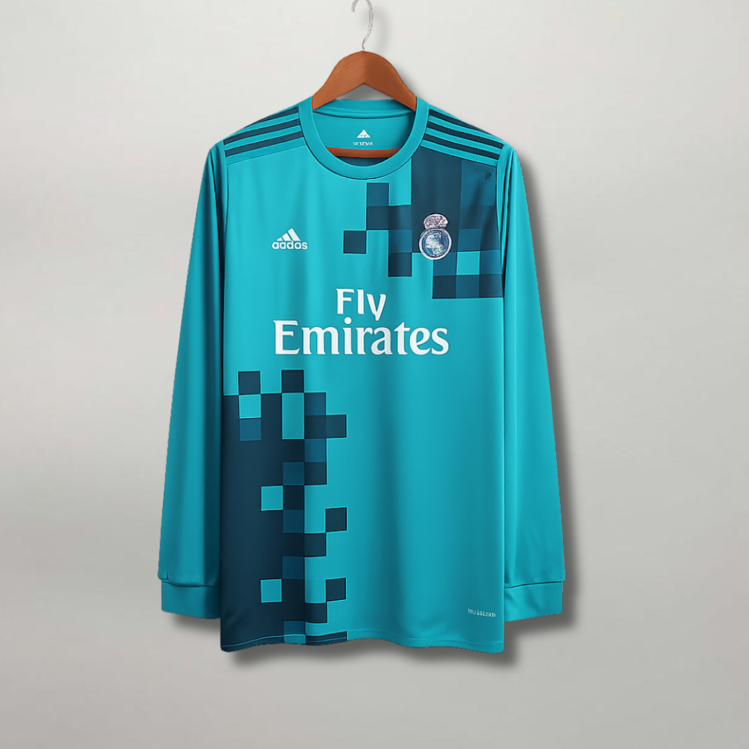 Maglia_Real_Madrid_Third_2017_18_a_maniche_lunghe_color_turchese_con_grafica_a_pixel_blu_scuro._0d04e865-e0e7-4d24-a32c-b273265e7041.png