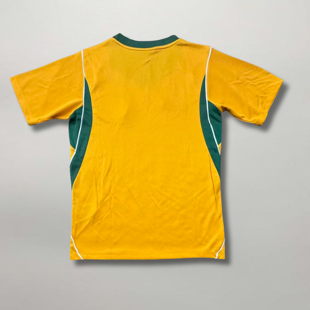 Vista_posteriore_della_prima_divisa_australiana_2026_gialla_e_verde_con_colletto_bicolore_sportivo.png