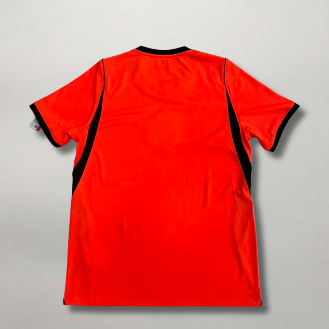 Vista_posteriore_della_prima_divisa_olandese_2026_arancione_con_finiture_nere_sui_fianchi.png