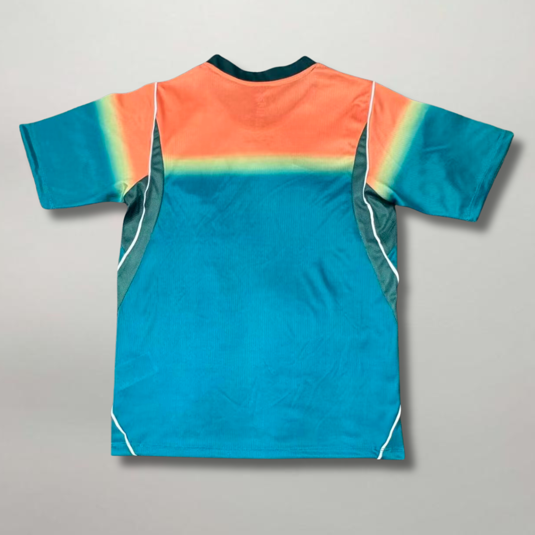 Vista_posteriore_della_seconda_divisa_australiana_2026_azzurro_acqua_con_pannelli_superiori_colorati_e_tessuto_traspirante.png